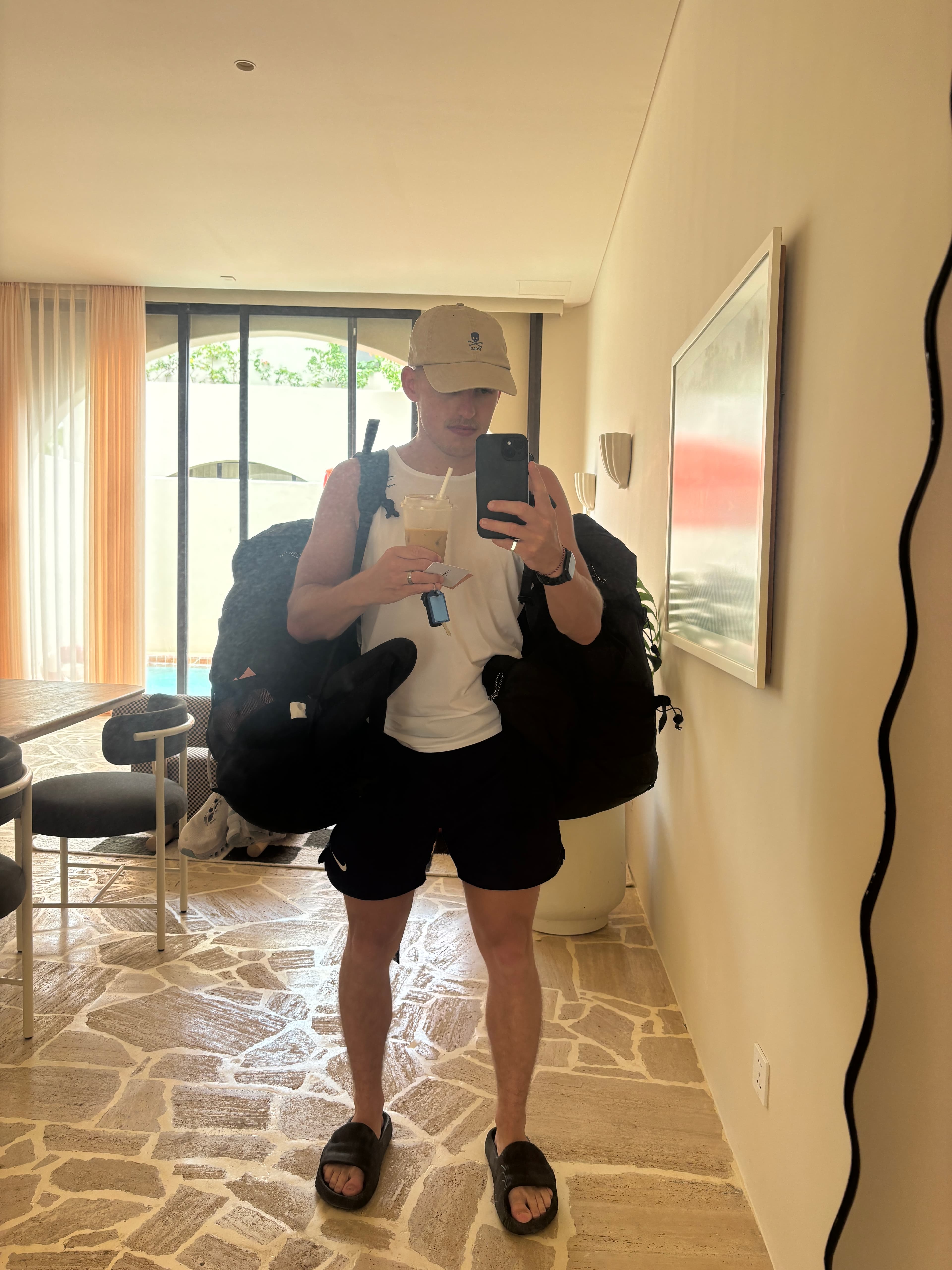 Clayton taking a mirror selfie packed up in a hotel hallway